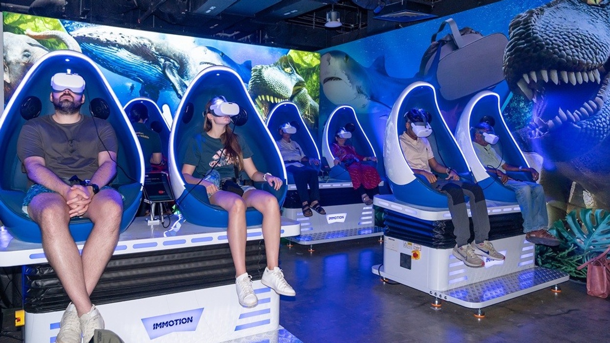 People in blue VR chairs experiencing the virtual reality 'Wild Explorer' exhibit.