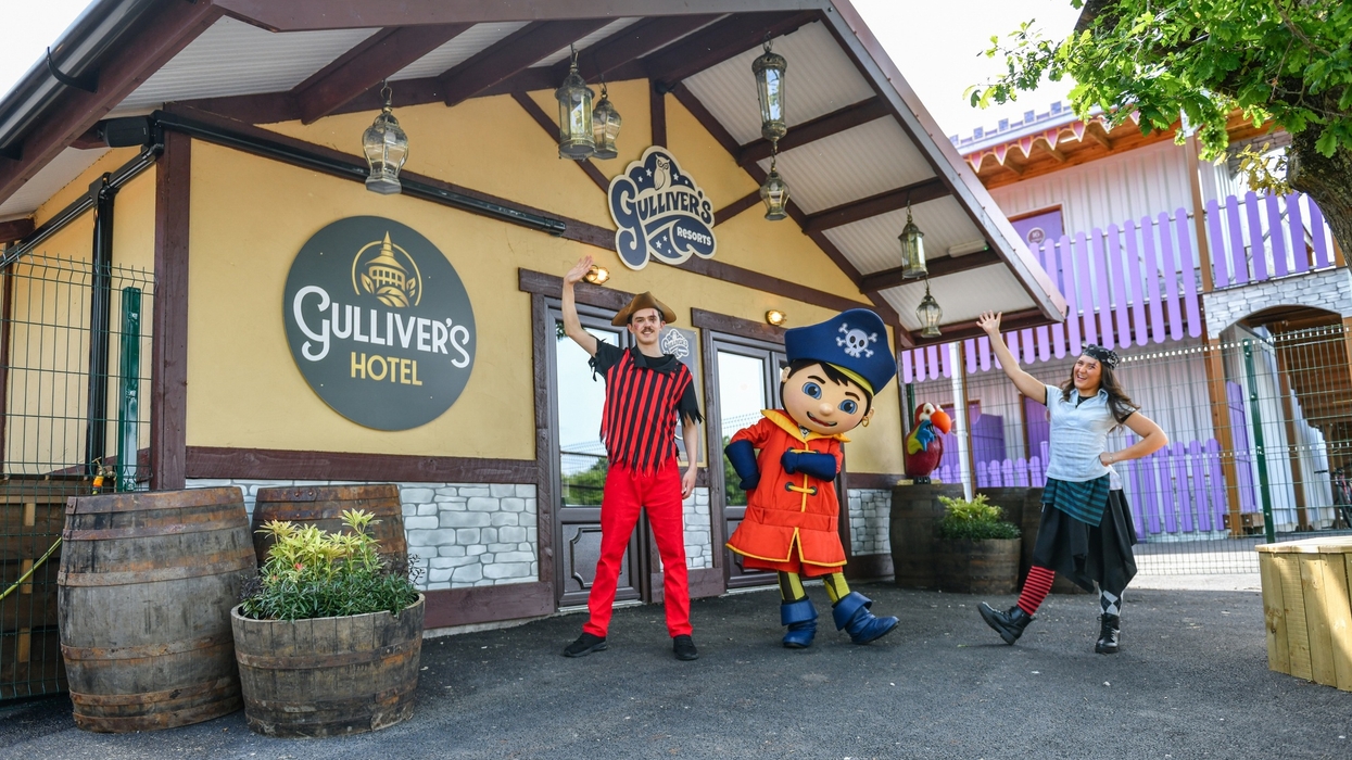 People in pirate costumes outside Gulliver's Hotel entrance, with a large character figure.