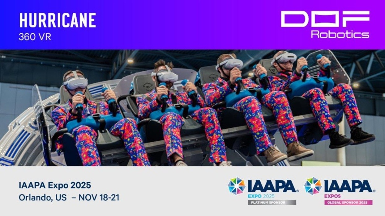 People in VR headsets ride a motion simulator at an expo, wearing colorful suits.