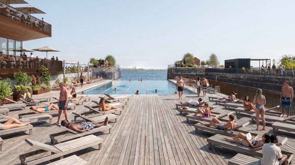 People lounging by a waterfront outdoor pool with a wooden deck in sunny weather.
