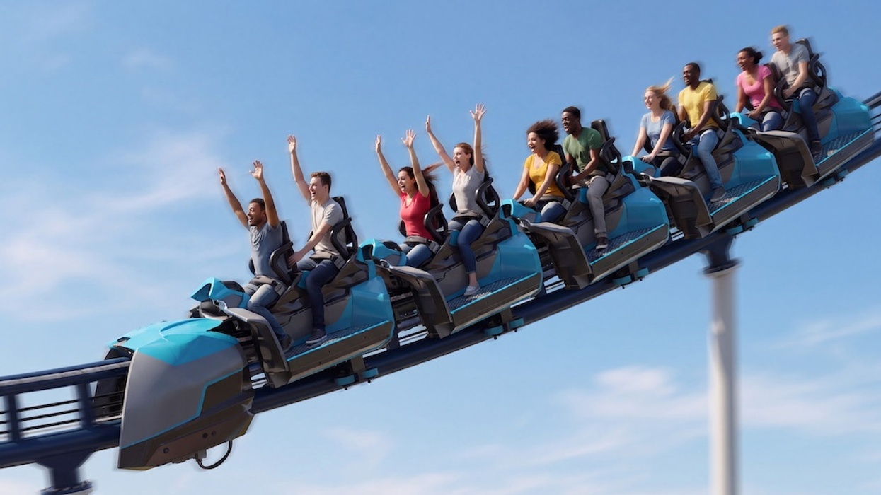 People on a roller coaster with hands up, enjoying a sunny ride.