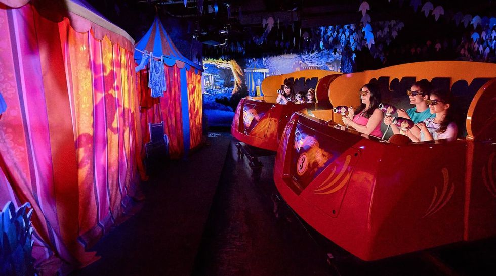 People on a theme park ride, Knott\u2019s Bear-y Tales, wearing 3D glasses, aiming at virtual targets.