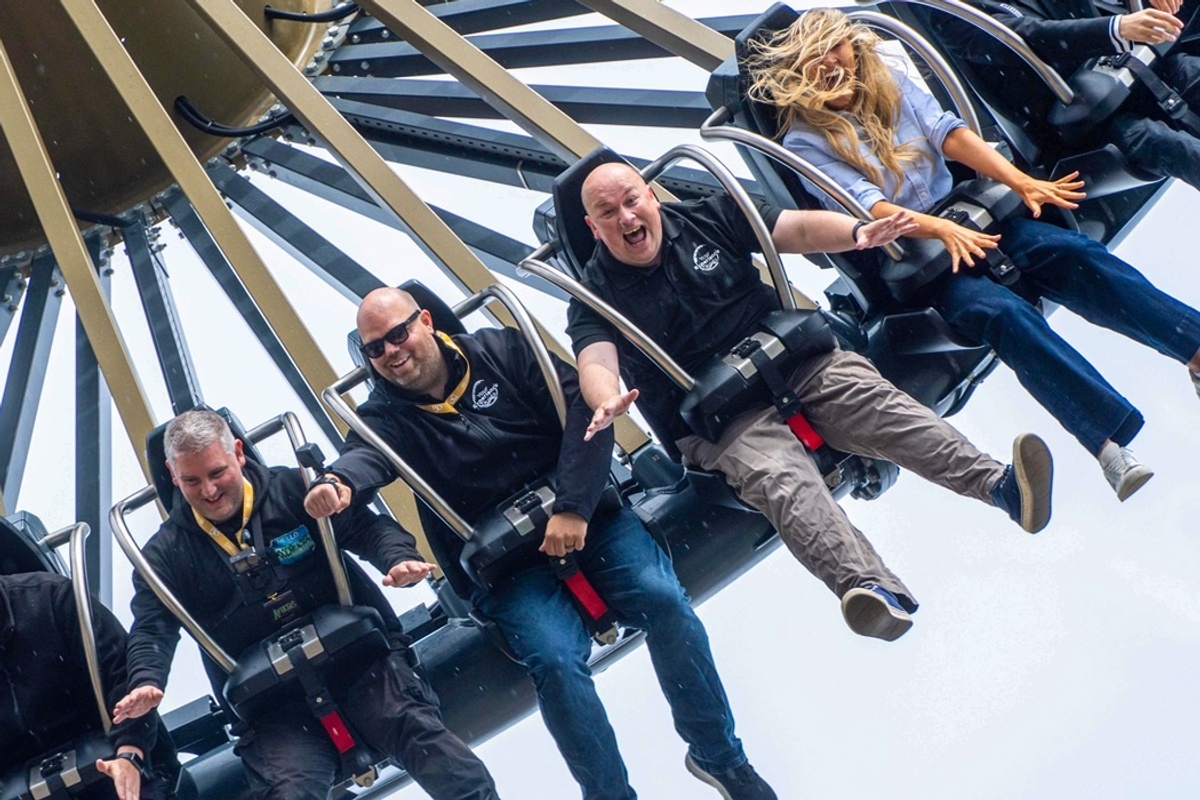 People on a thrilling amusement park ride named Aviktas, laughing and holding on tightly.