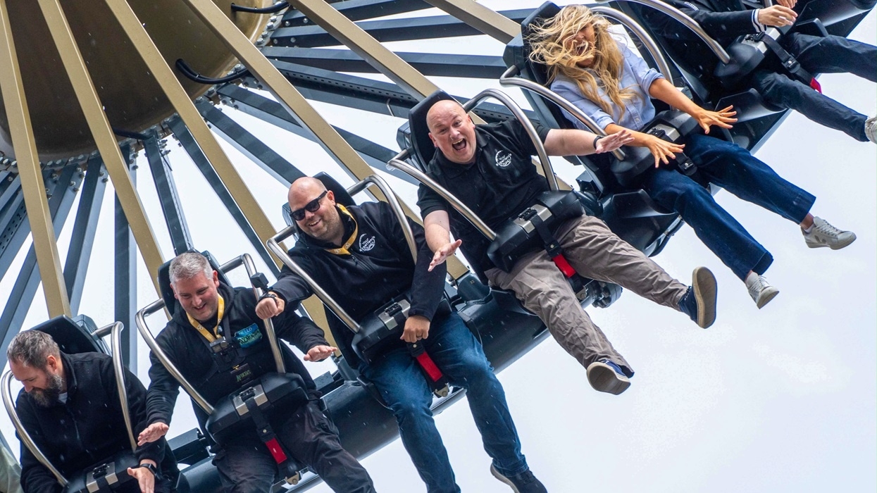 People on a thrilling amusement park ride named Aviktas, laughing and holding on tightly.