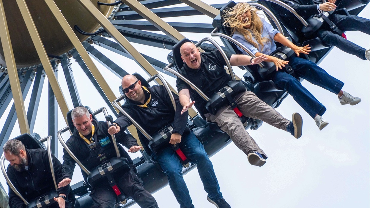 People on a thrilling amusement park ride named Aviktas, laughing and holding on tightly.