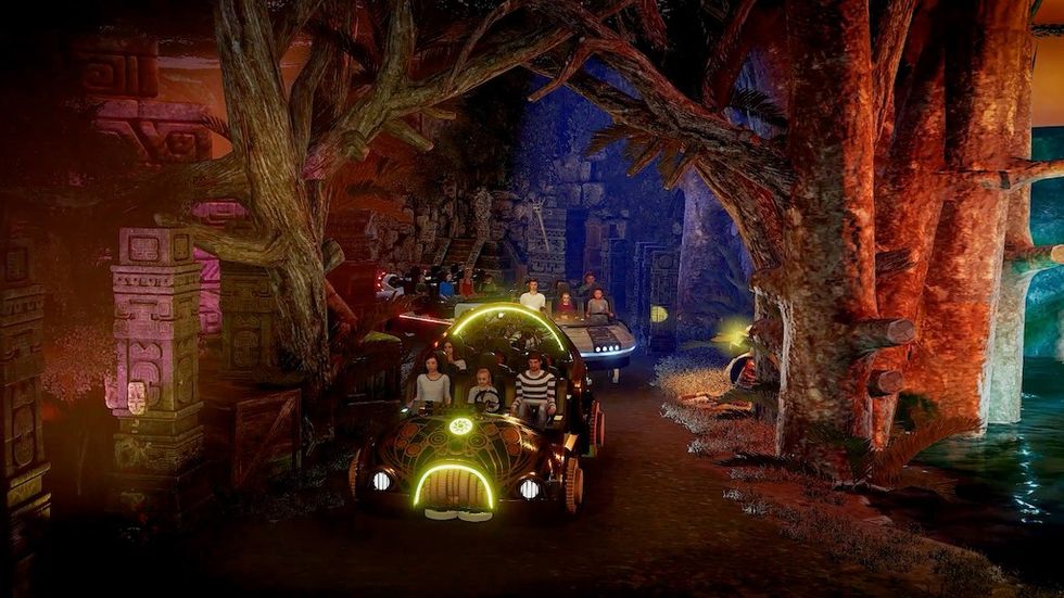 People on an illuminated ride through a jungle-themed attraction with glowing decorations.