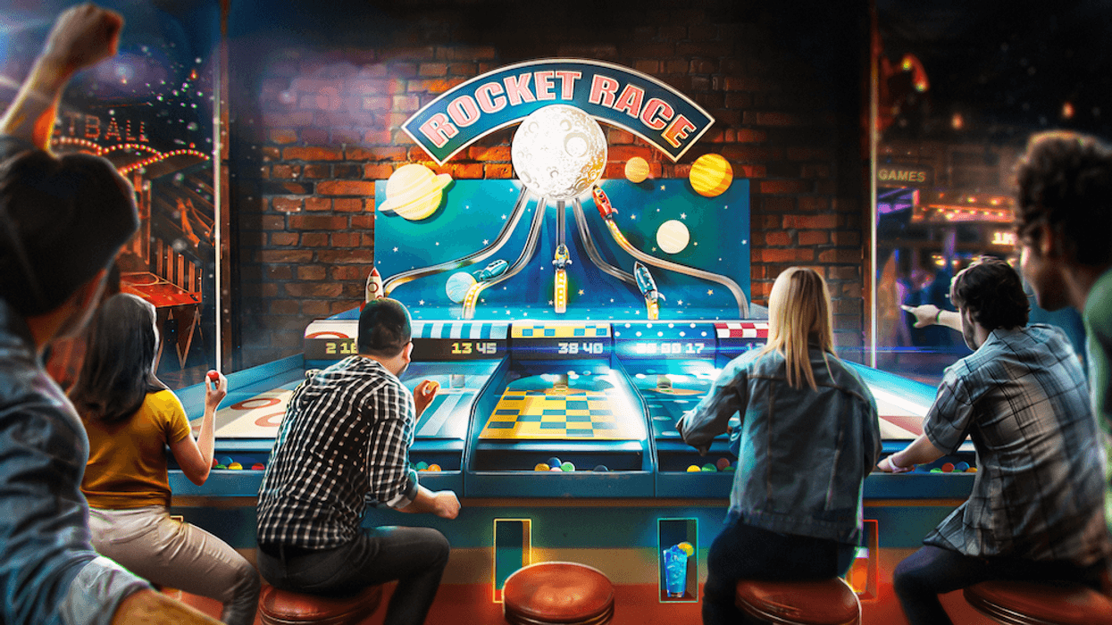 People playing an arcade game called "Rocket Race" with colorful lights and cheering.