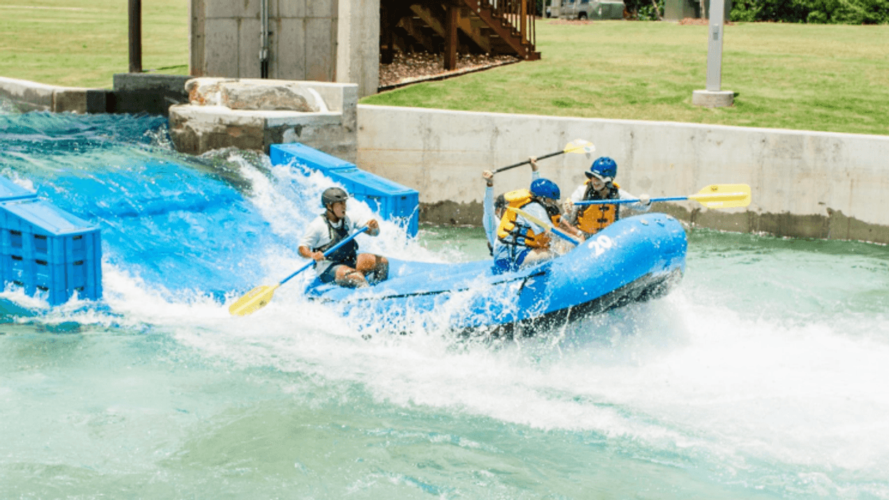 People rafting in a blue raft on at Montgomery Whitewater Center