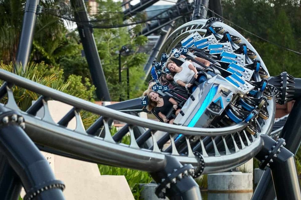 People riding a twisting roller coaster with expressions of excitement at Universal's Islands of Adventure