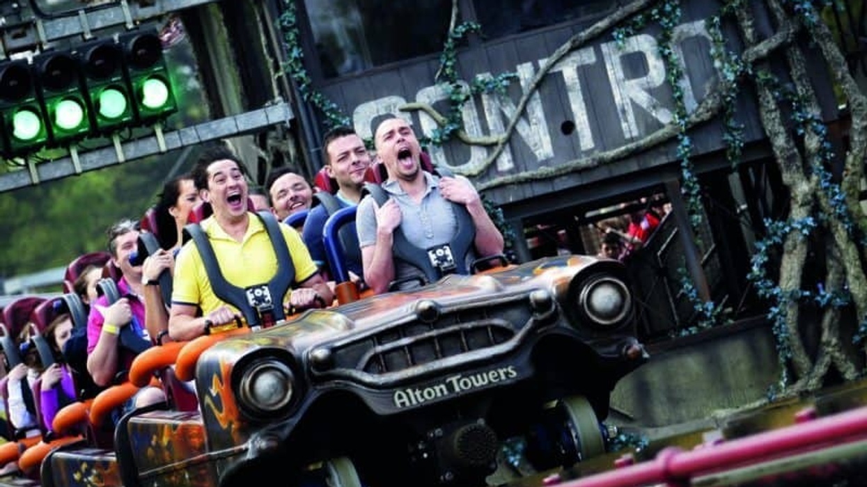 People screaming on a roller coaster at Alton Towers with a jungle theme backdrop.