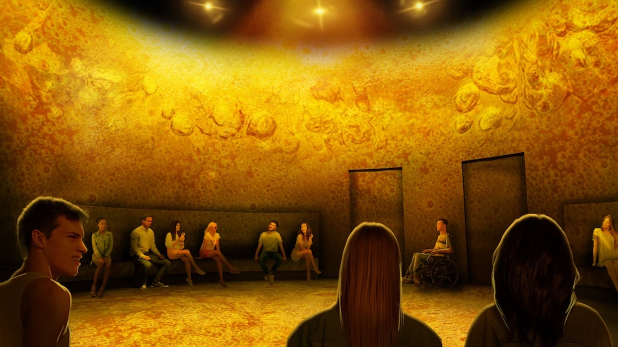 People seated in a circular, warmly lit room with orange textured walls, as if inside a pint of beer, at Balashi Beer Experience