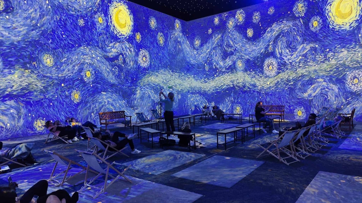 People sitting in immersive van gogh exhibition