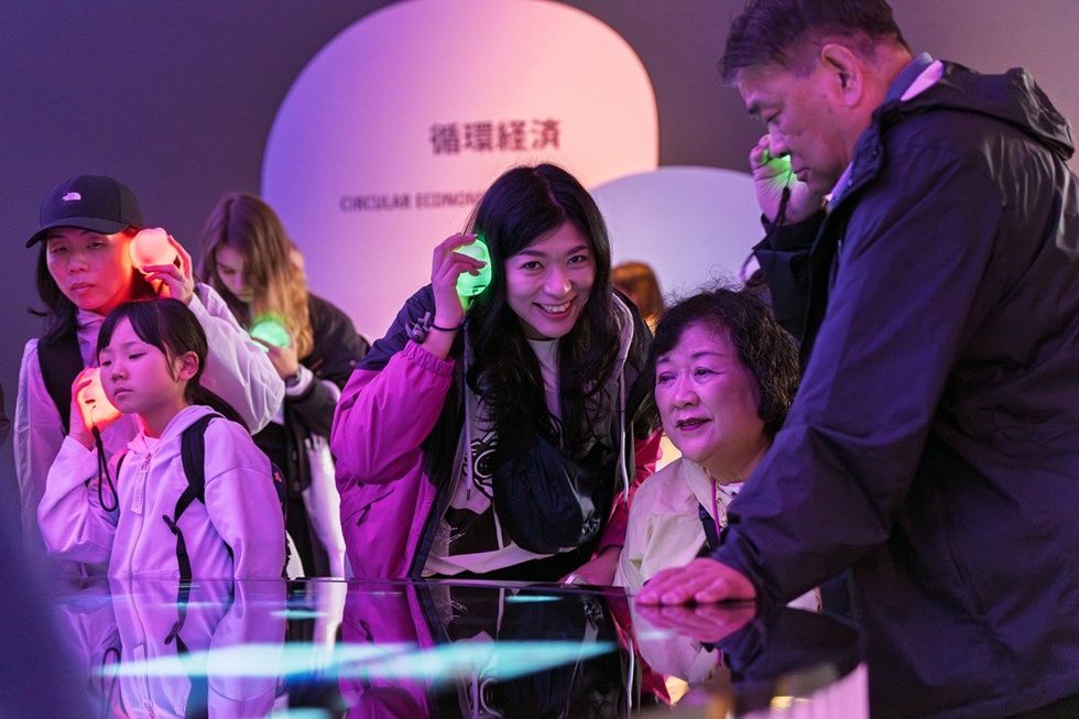People using colourful illuminated headsets at an exhibit.