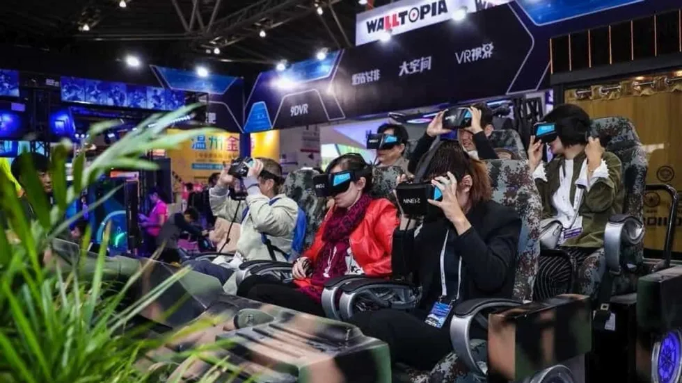 People using VR headsets in a seated simulator experience at an exhibition.