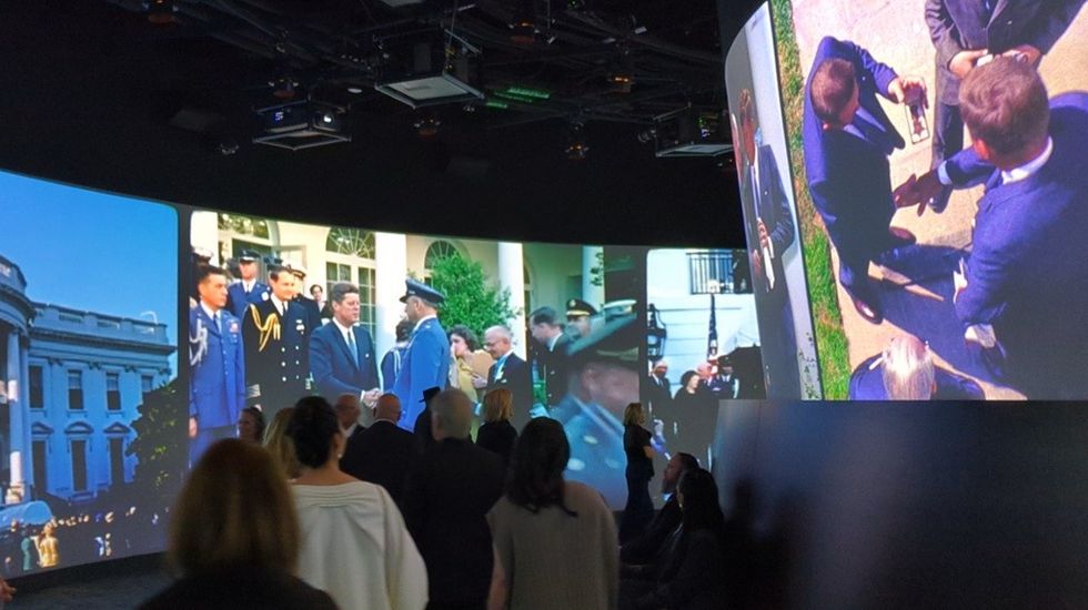 People view immersive political history projections in a curved room.