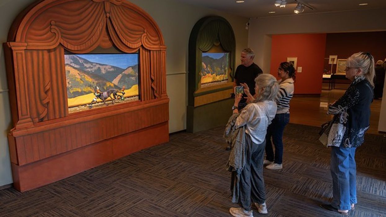People viewing framed 3D landscapes in a museum gallery.