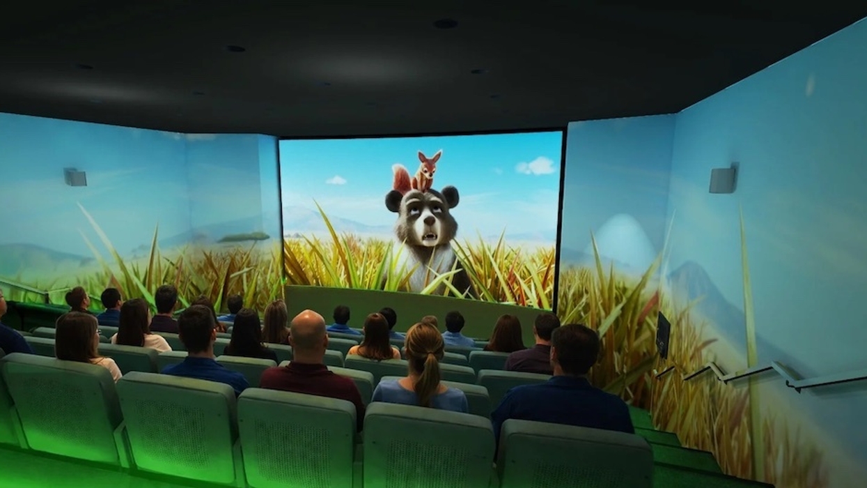 People watching an animated bear and squirrel on a multi-screen 4D cinema setup.