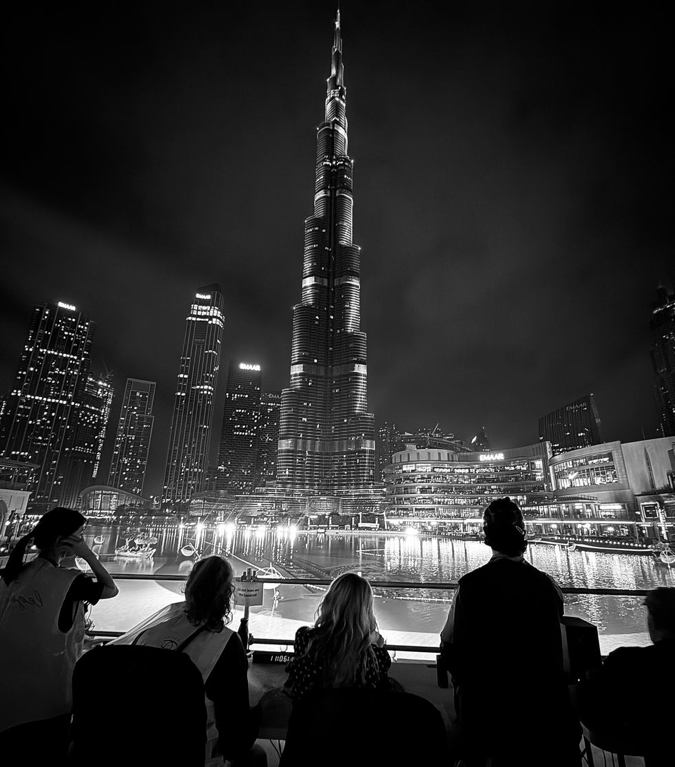 People watching Burj Khalifa at night, Dubai skyline in black and white.