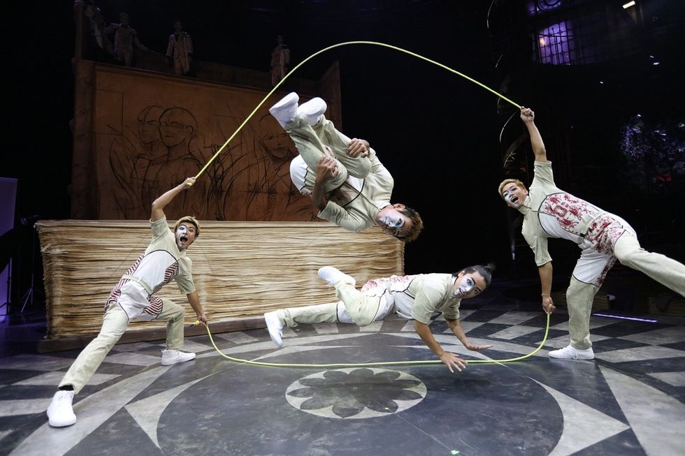 Performers in costume execute a dynamic jump rope routine on stage.