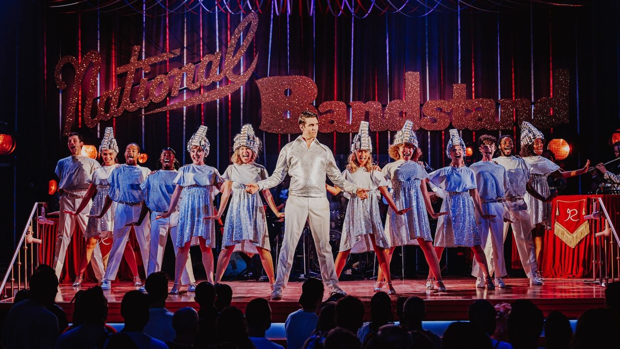 Performers in sparkly outfits on stage under "National Bandstand" sign.
