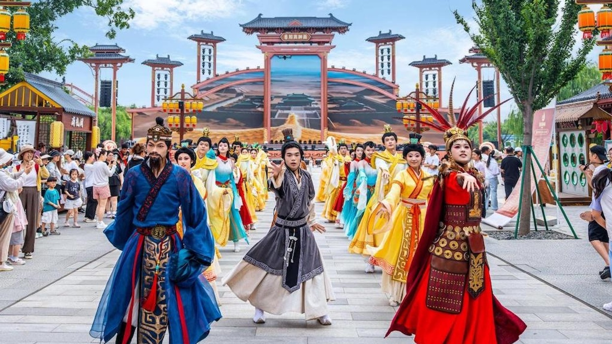 Performers in traditional Chinese costumes in a cultural parade at Fantawild Yinshang Legend