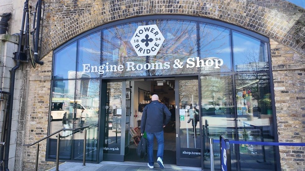 Person entering Tower Bridge Engine Rooms & Shop with brick archway.