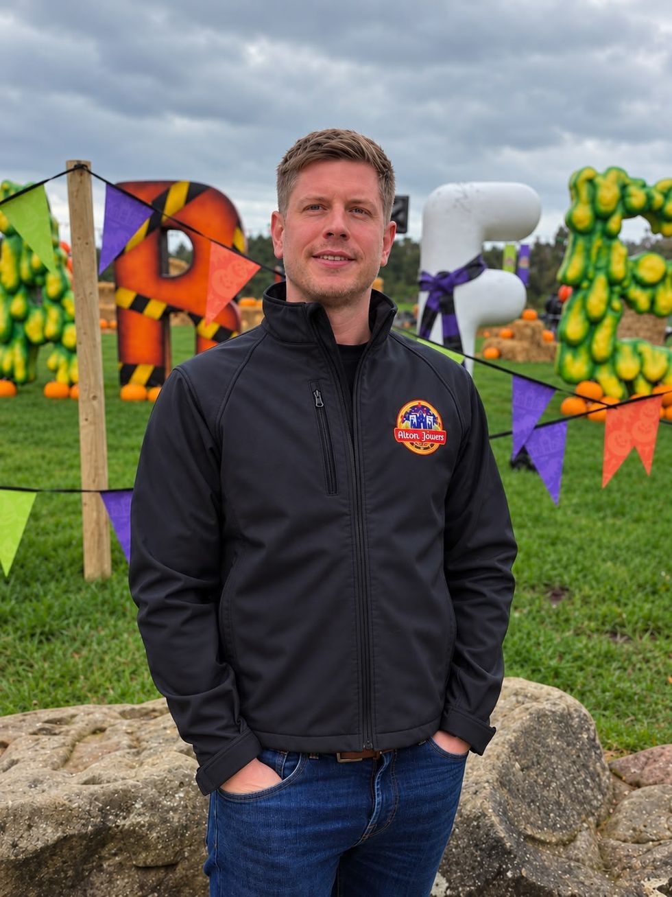 Person in a black jacket at a colorful, festive outdoor setting.