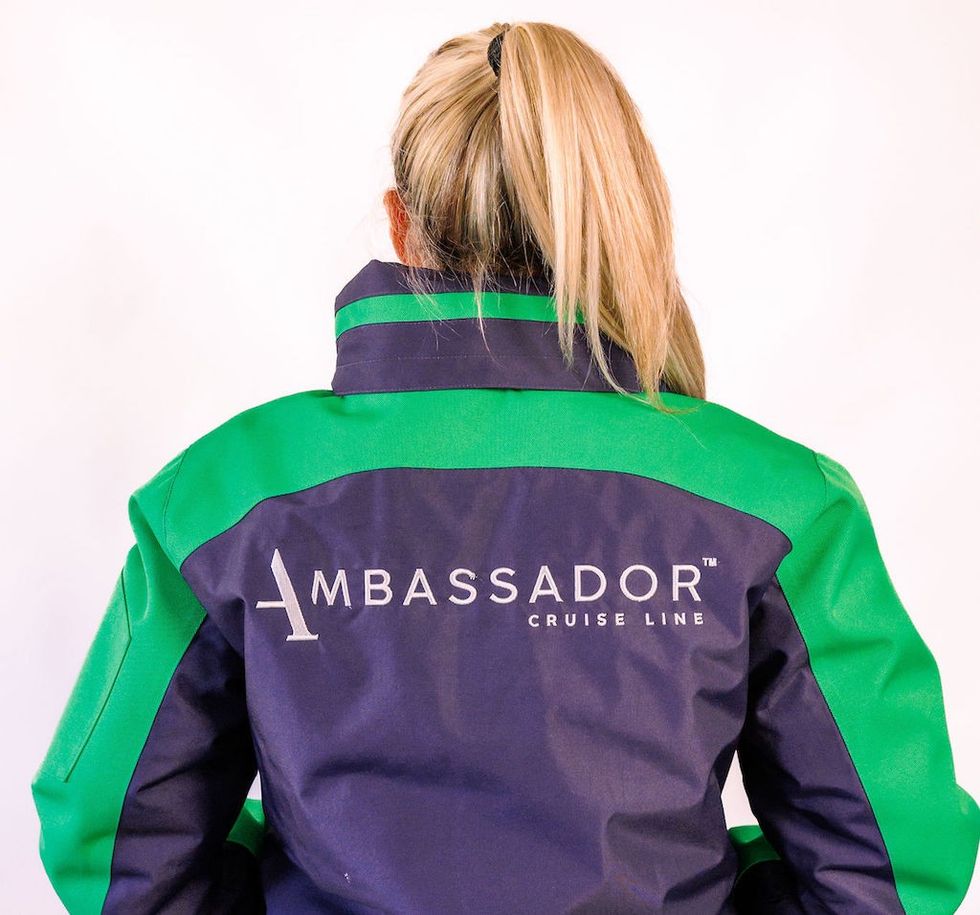 Person in a green and navy jacket with "Ambassador Cruise Line" logo on the back.