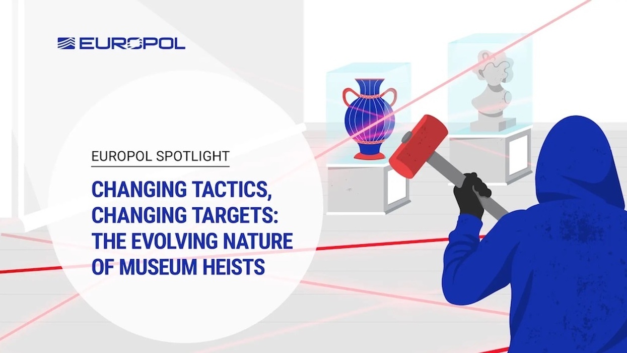 Person in hoodie with sledgehammer among museum artifacts and security lasers.
