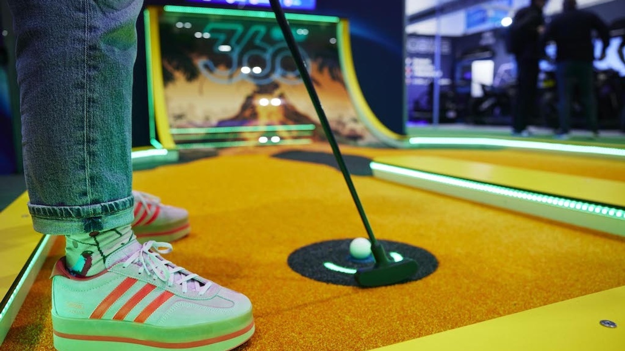 Person in retro sneakers playing 360Golf on a vibrant, colorful course.