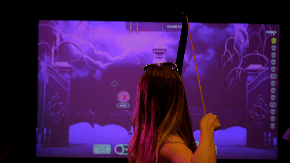 Person in VR archery game, aiming at a target on a purple stormy screen.