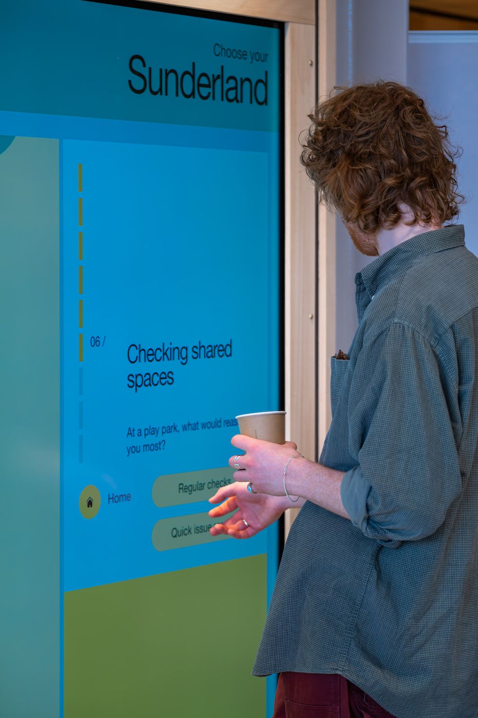 Person interacting with a touchscreen display about shared spaces in Sunderland.