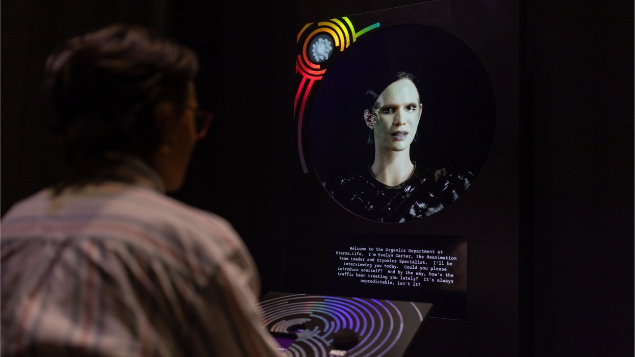 Person interacts with a futuristic AI hologram displaying text on a dark screen.