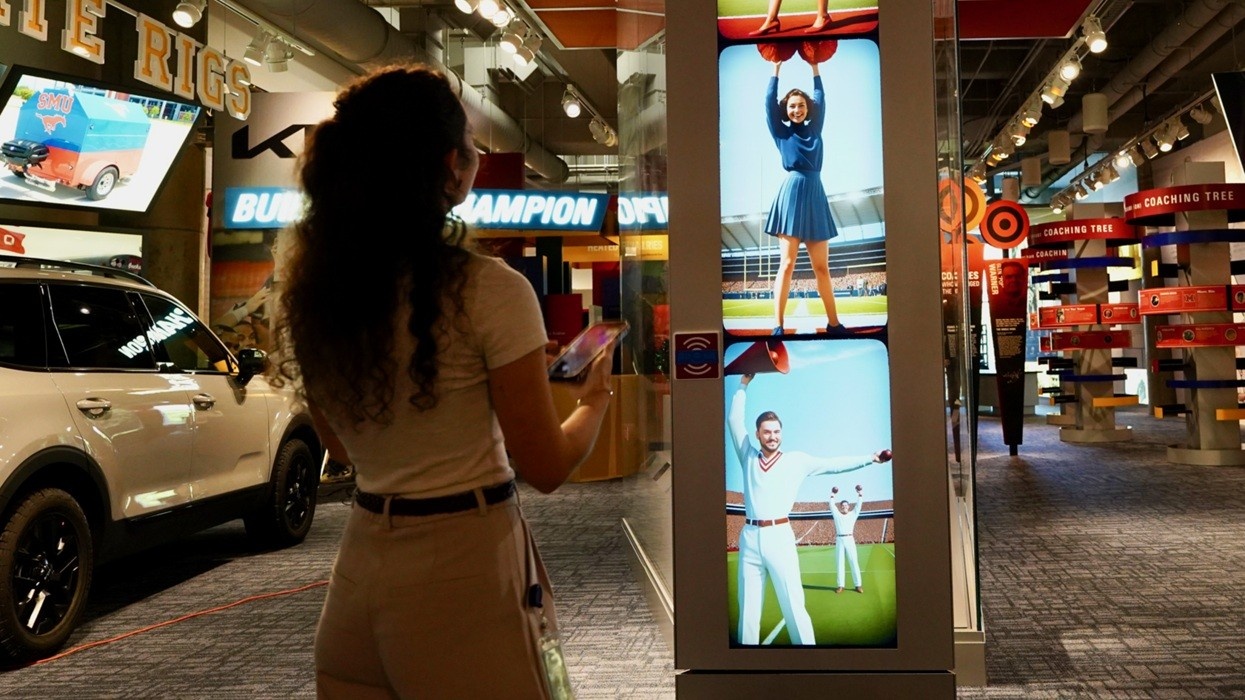 Person observing digital sports displays in an exhibition.