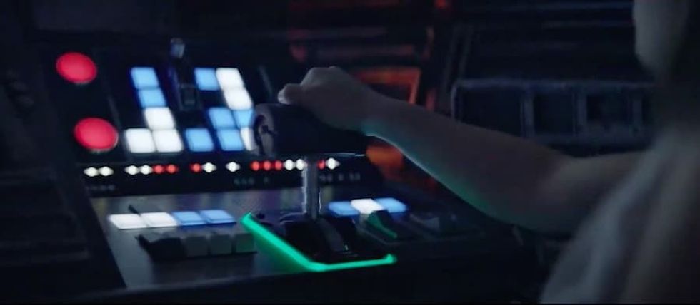 Person operating a futuristic control panel on Millennium Falcon: Smuggler's Run ride with illuminated buttons and a joystick.