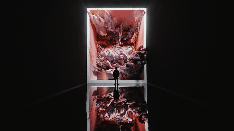 Person stands in dark gallery at Dataland, viewing large, colorful abstract digital art.