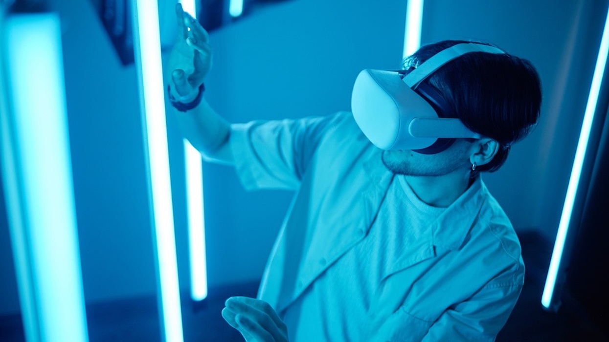 Person using VR headset in a room with glowing blue lights.