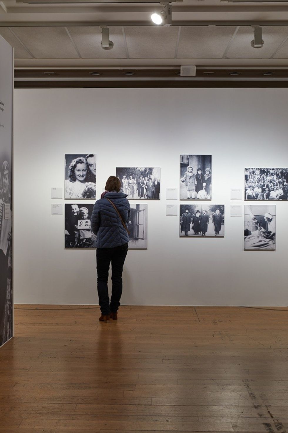 Person viewing black-and-white photos in a gallery exhibition.