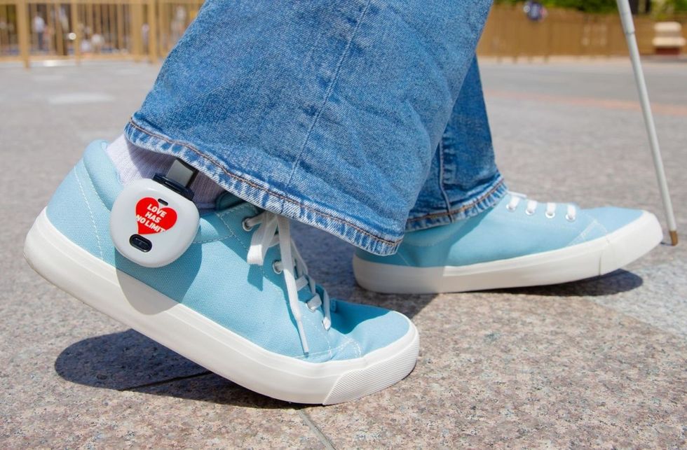 Person walking with a cane, wearing blue sneakers and denim jeans at Universal Studios Japan