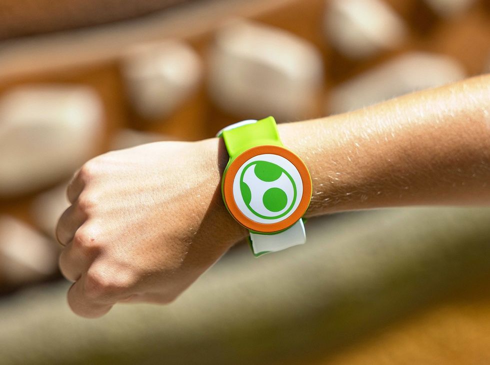 Person wearing a green and white wristband with a circular design.