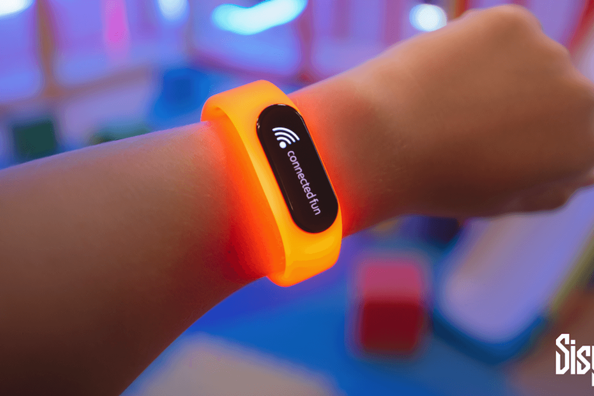 Person wearing an orange smart wristband from SisyFox with "connected fun" showing on display.