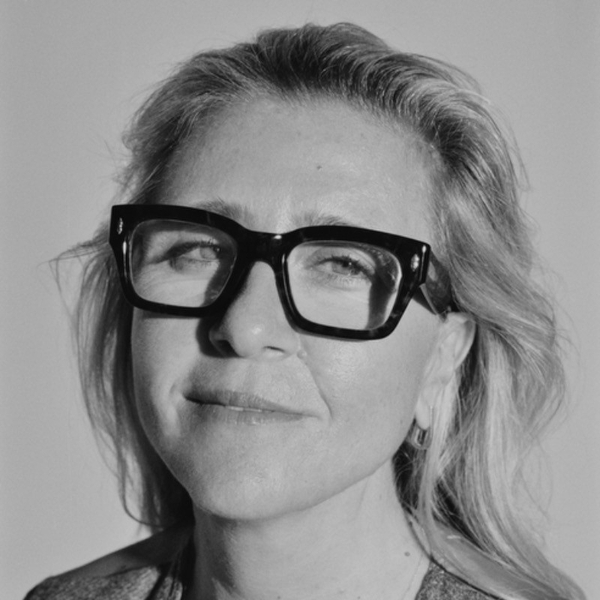 Person with glasses, light hair, and a gentle smile in a black and white photo.