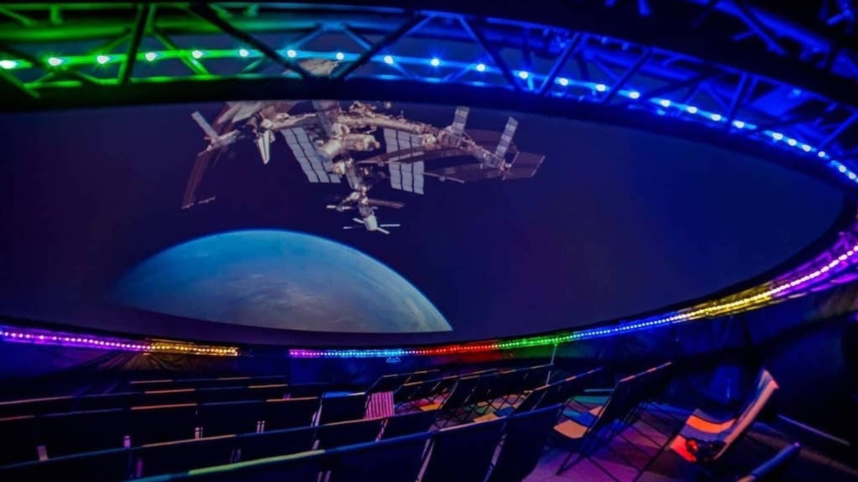 Planetarium dome with space station projection and colorful LED lights.