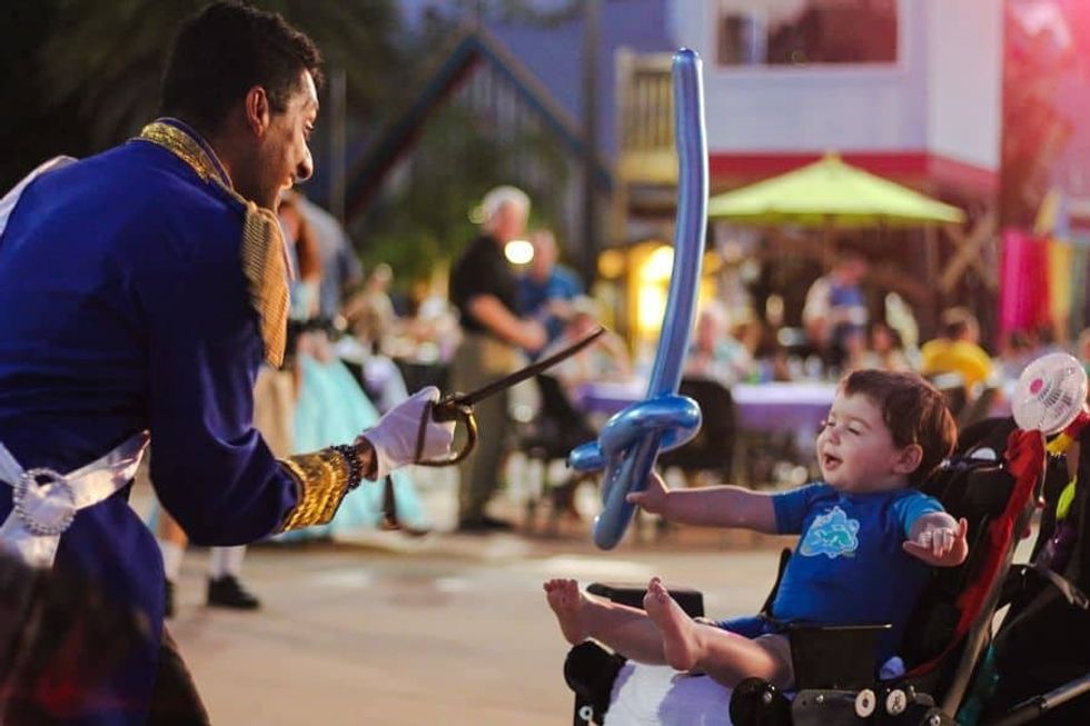 Prince at Give Kids The World interacts with a young boy on wheelchair