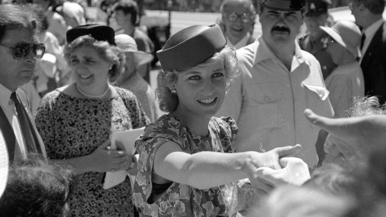 Princess Diana in a floral dress greeting a crowd, with police and bystanders nearby.