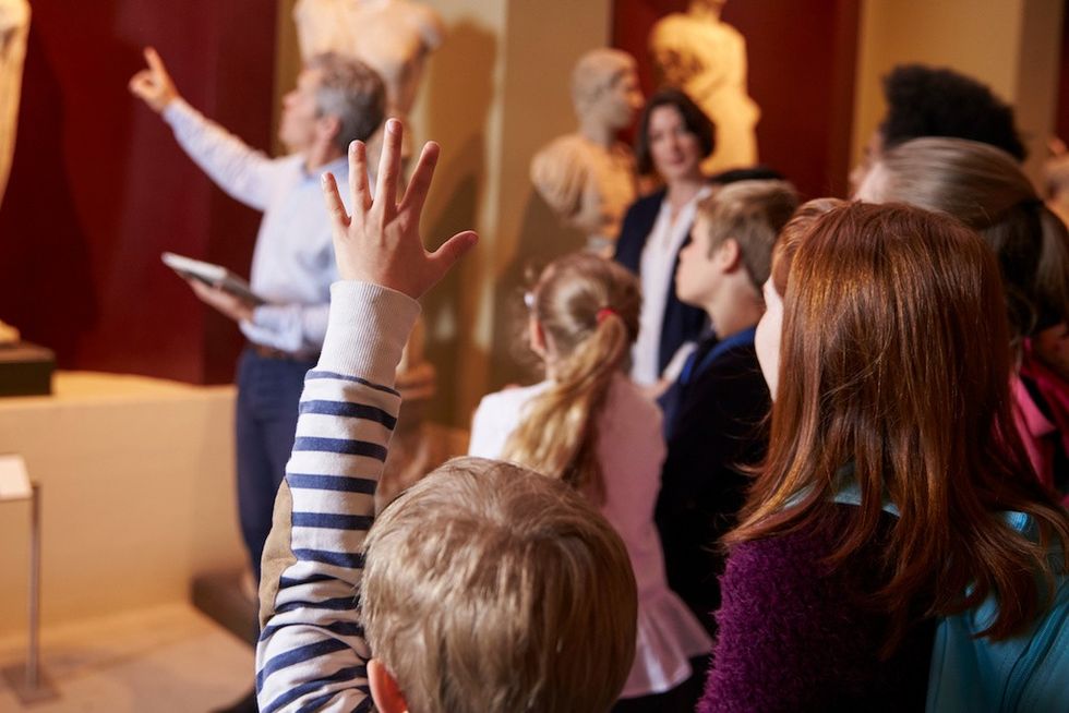 Pupils And Teacher On School Field Trip To Museum With Guide creating the visitor experience