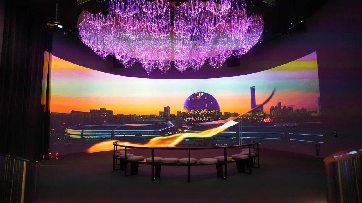 Purple chandelier above a panoramic cityscape display with a circular seating area at ALEM AI.
