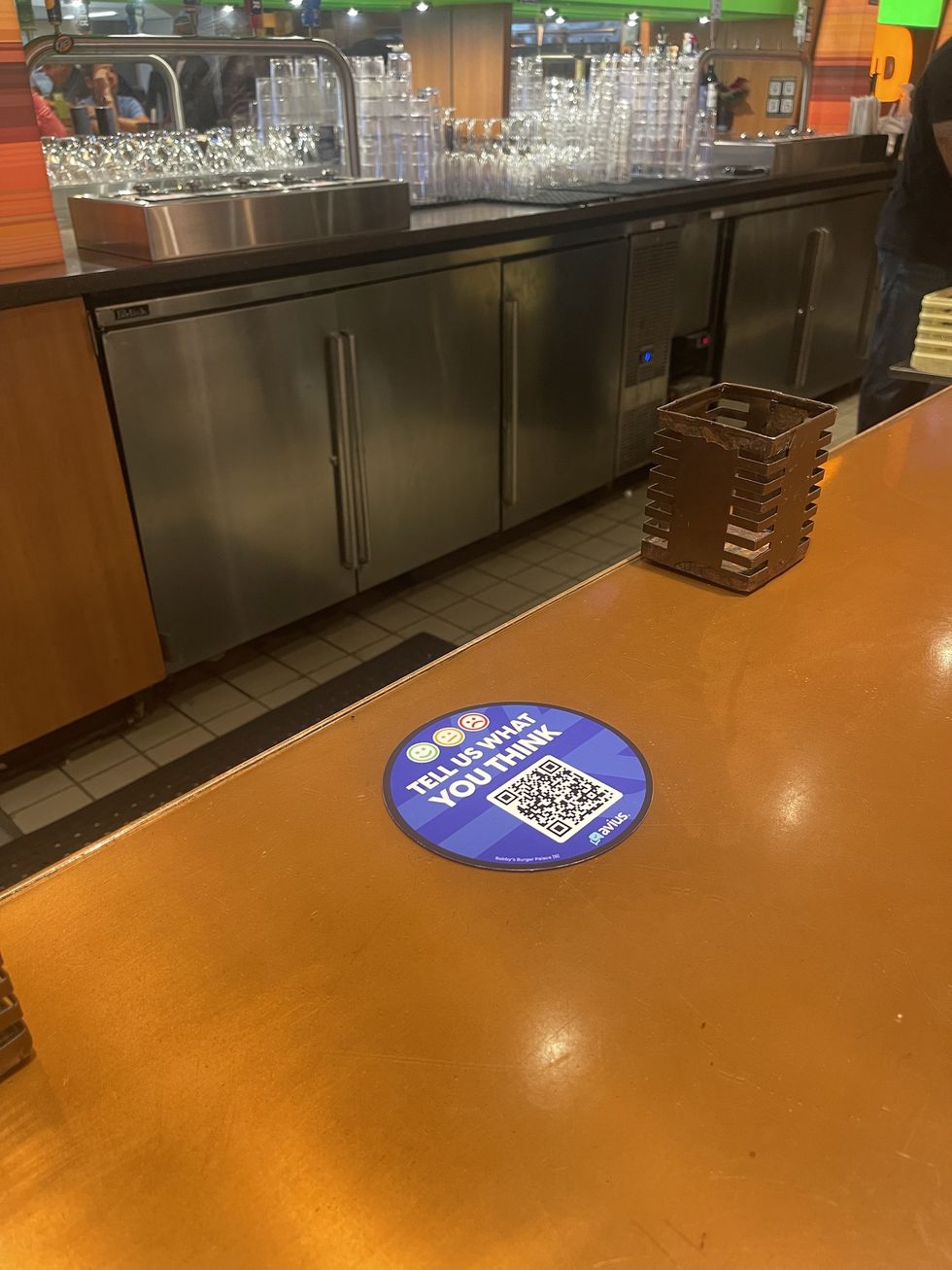 QR code on a counter asking for feedback in a restaurant setting.