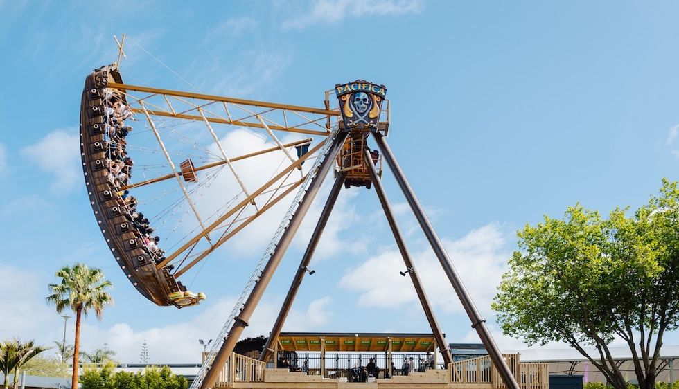 Rainbow's End pirate ship ride Pacifica by HUSS, swinging under a clear blue sky.