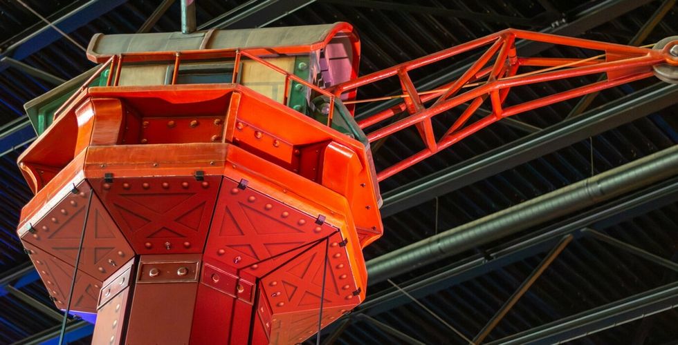 Red industrial crane themed Tower ride at Bommelwereld, in a building with metal trusses above.